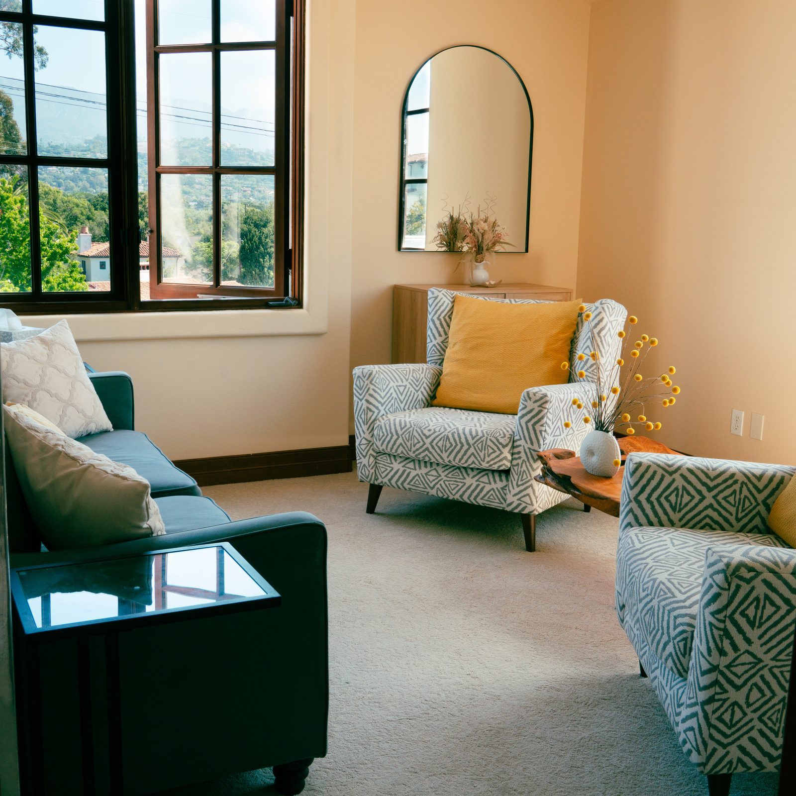 Deborah Batres' therapy office in Santa Barbara: patterned armchairs, a soft sofa, and a window framing the mountains